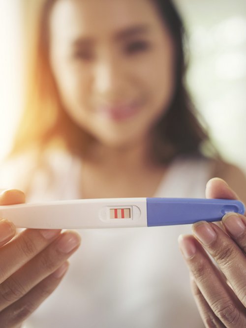 Reprodução Humana Mulher segurando seu teste de gravidez positivo
